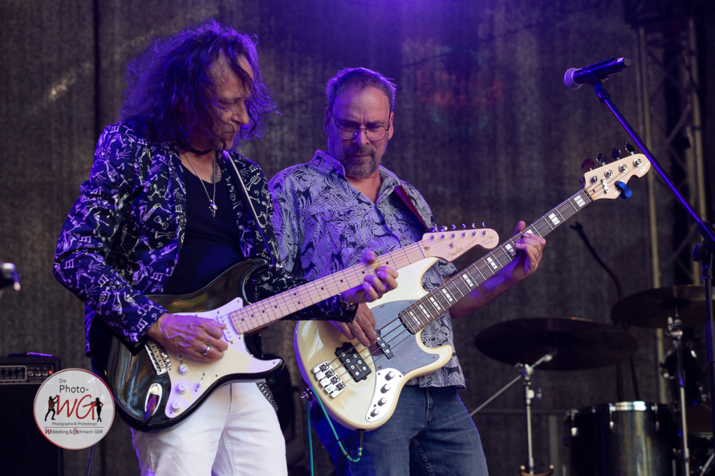Zwei Musiker spielen leidenschaftlich Gitarre und Bass auf der Bühne. | © Arnd Woebbeking