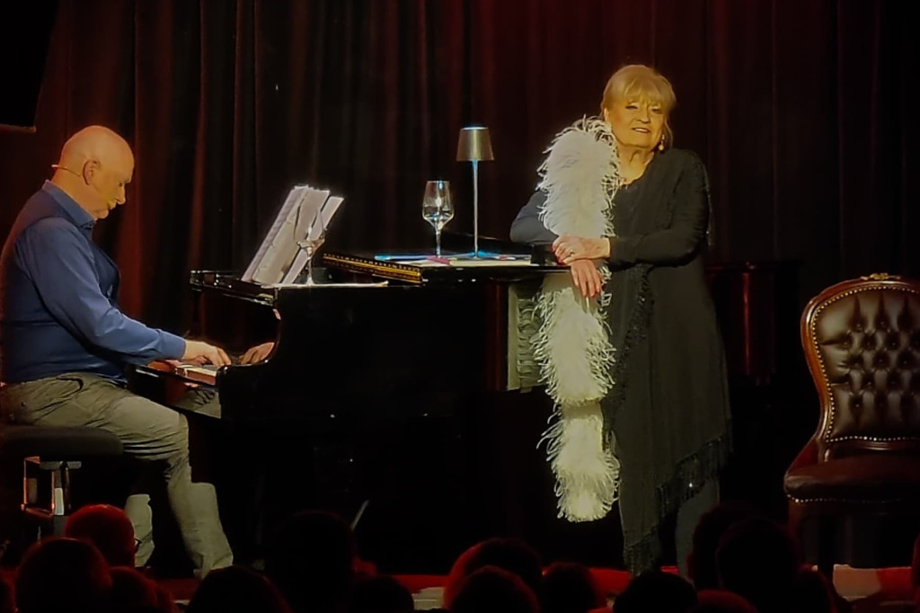 Margit Frank singt am Klavier bei einem Dinner-Event auf der Bühne.