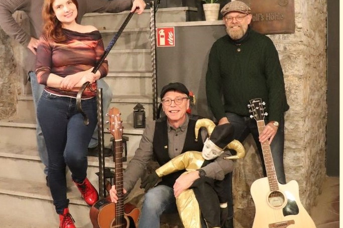 Vier Musiker posieren mit Gitarren in einer gemütlichen Location. | © Name